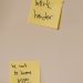 Yellow sticky notes with motivational phrases posted on a white wall, inspiring action.